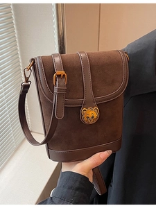Retro dark brown suede crossbody bucket bag with golden bear clasp and adjustable strap