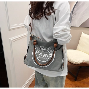 Détail du cabas en toile grise avec bandoulière en cuir et imprimé Paris rétro