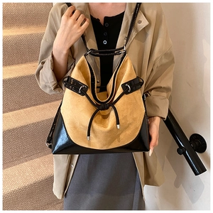 Detail of suede tote bag showing yellow and black patchwork with decorative knot