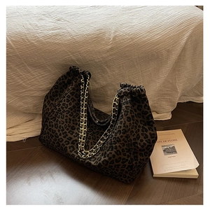 Close-up of leopard print tote bag featuring gold chain straps and pleated details