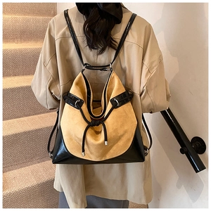 Detail of suede bucket backpack with contrast stitching and adjustable silver hardware