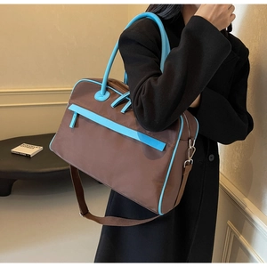 Detail der Reisetasche mit blauem Lederbesatz, Nylongewebe und verstellbarem Schultergurt