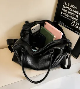 Interior view of large black leather travel bag showing spacious compartments for gadgets