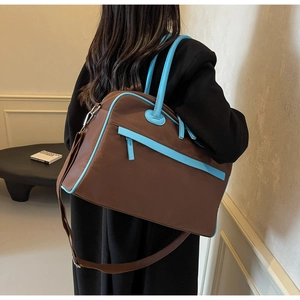 Detail der großen Reisetasche mit blauem Lederbesatz und braunem Stoffmaterial