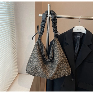 Detail der Hobo-Tasche mit Leopardenmuster, schwarzem Falten-Griff und Tunnelzug-Verschluss