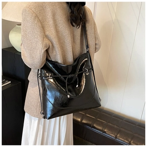 Minimalist large black faux leather tote worn by model in a stylish urban setting