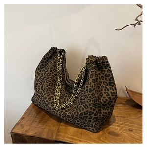 Detail of leopard print tote bag featuring gold chain strap and drawstring closure