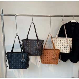 Vue détaillée de quatre sacs cabas colorés à motifs avec breloques de chien mignon