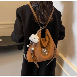 Sac à dos cabas en nylon marron avec logo M en métal et breloque nuage blanc sur modèle