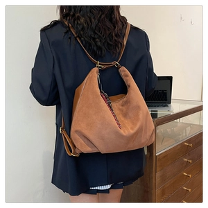 Detail of vintage brown suede backpack with minimalist straps on a female model