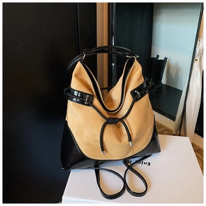 Detail of suede and patent leather patchwork bag with drawstring and silver hardware