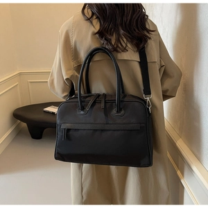 Rückansicht eines Models mit großer schwarzer multifunktionaler Nylon-Reisetasche