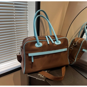 Detailansicht der großen Reisetasche in Braun und Himmelblau mit abnehmbarem Gurt