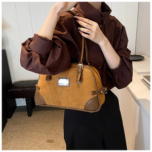 Dettaglio borsa Boston in camoscio caramello con cinturini in pelle marrone scuro