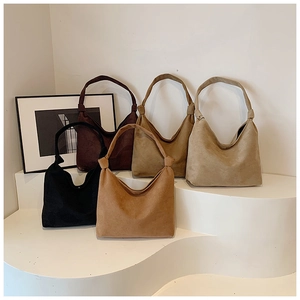 Detail view of five assorted matte suede tote bags featuring unique knot handle designs