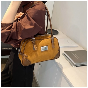 Dettaglio borsa Boston in camoscio marrone con fibbie argentate e finiture stile retrò