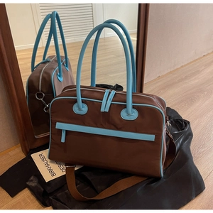 Detailansicht der großen Reisetasche mit blauen Griffen und Reißverschlusstasche