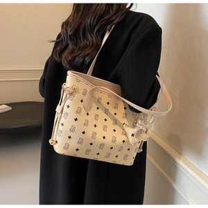 Détail du sac cabas beige avec motifs d'ours, matelassage losange et breloque chic