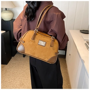Dettaglio della borsa Boston marrone caramello con contrasto in pelle scamosciata e metallo
