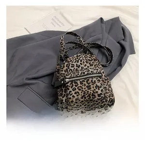 Close-up of leopard print backpack with metal zipper pocket on a stylish background