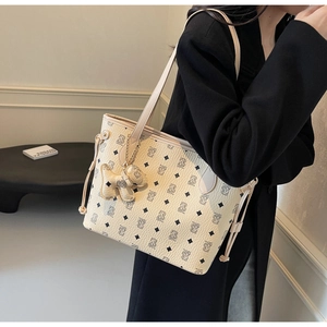 Gros plan du sac cabas beige avec monogramme ours et accessoire de charme ours en 3D