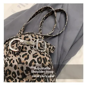 Detail of adjustable leopard print strap with silver metal hook and D-ring buckle