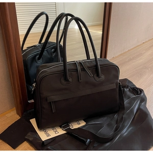 Detail einer großen schwarzen Reisetasche aus wasserfestem Nylon mit Lederakzenten