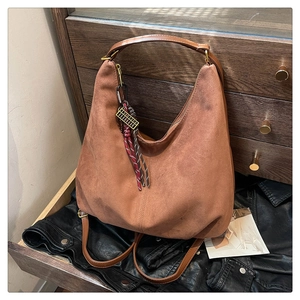 Detail of vintage brown suede Hobo bag with decorative metal abacus and tassel