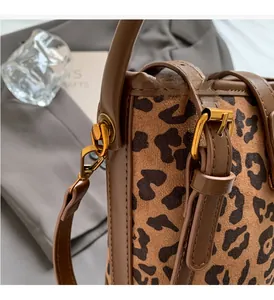 Detailaufnahme der Leoparden-Beuteltasche mit goldener Hardware und braunem Lederbesatz