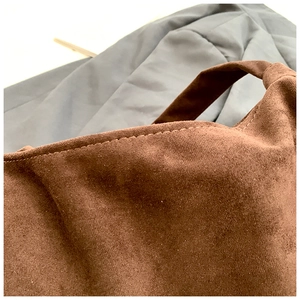 Close-up of vintage brown suede tote bag showing contrast stitching and soft matte texture