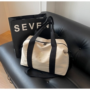 Détail de la texture en toile beige de haute qualité et des sangles noires du sac de voyage