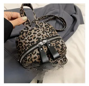Close-up of leopard print backpack with silver dual zippers and leather pull tabs