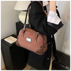 Borsa Boston marrone opaca con rifiniture in pelle indossata da modella in interno