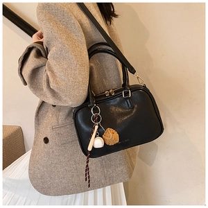 Borsa Boston nera con ciondolo da baseball, indossata da una modella con blazer