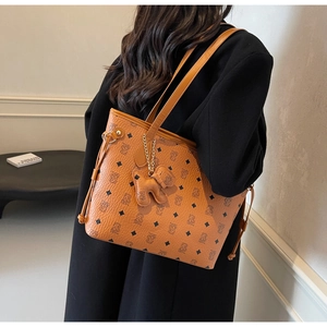 Détail d'un sac cabas marron avec imprimé ours vintage et un joli pendentif ours
