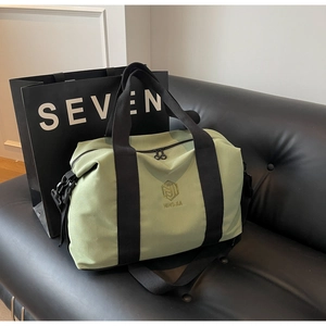 Détail du sac de voyage vert avec logo doré, sangles durables et double fermeture