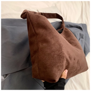 Close-up of dark coffee suede Hobo bag with stylish knotted handle and vintage texture