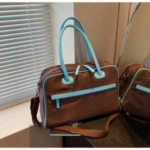 Detailansicht der Reisetasche mit blauen Akzenten und verstellbarem Schultergurt
