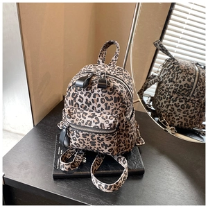 Detailed macro view of the leopard print mini backpack showing its texture and canvas straps