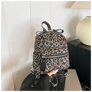 Detailed close-up of a mini leopard print backpack featuring decorative black leather bows