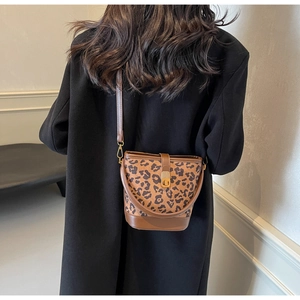 Detail der Leoparden-Beuteltasche mit braunem Lederboden und goldenem Drehverschluss