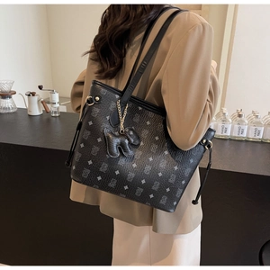 Détail d'un grand sac cabas en cuir noir avec motif ours et cordon de serrage latéral