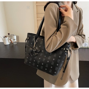 Détail du sac cabas noir avec motifs ours et pendentif éléphant sur les anses