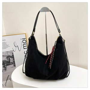 Detail of black frosted hobo bag with tricolor woven tassel and golden metal hardware