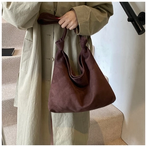 Deep brown suede tote bag featuring a decorative knotted shoulder strap detail