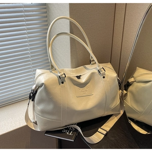Detail of white PU leather travel bag with adjustable shoulder strap and logo