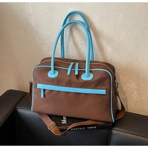Nahaufnahme der braunen Nylontasche mit hellblauen Kunstlederbesätzen und Griffen