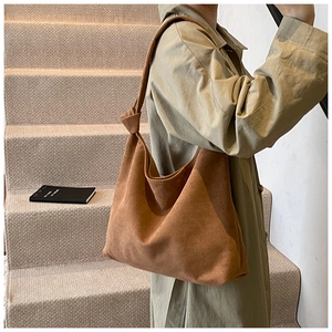 Detail of a large vintage brown suede tote bag with knot strap detail on a hobo bag