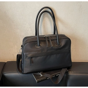 Detailansicht der schwarzen Nylon-Reisetasche mit Lederbesatz und Schultergurt
