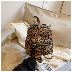 Close-up of leopard print mini backpack with zipper pockets on a white chair background
